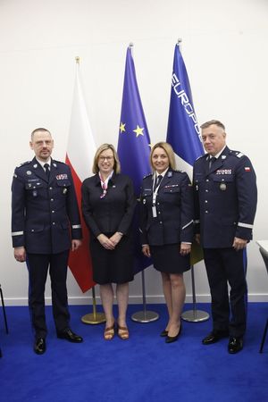 Dwóch umundurowanych oficerów policji pozuje do zdjęcia z dwoma kobietami.